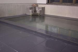 a tile floor with a fountain in a building at Hotel Myosen in Myoko