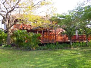 a wooden house with a deck in a yard at Monzi Safari Lodge in St Lucia