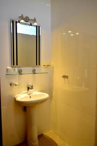 羅威那的住宿－羅密簡易別墅，浴室配有盥洗盆和带镜子的淋浴