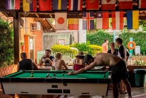 a group of people standing around a pool table at Bonito HI Hostel e Pousada in Bonito