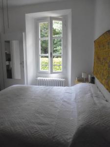 a white bedroom with a large bed and a window at Appartamento Al numero 11 in Como
