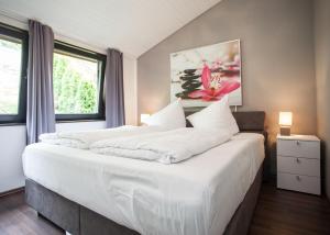 ein Schlafzimmer mit einem großen Bett mit weißer Bettwäsche in der Unterkunft Margaritenweg 31-F, Winterberg-Niedersfeld in Winterberg