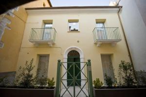 a building with two balconies and a green door at Vico Amato Residenza in Sulmona