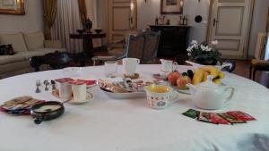 una mesa con un mantel blanco con fruta. en Villa Mereghetti, en Corbetta