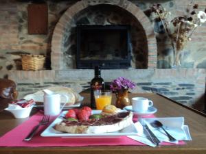 Una mesa con un plato de comida sobre una mesa. en Hostal Rural Molino Del Bombo, en Aracena