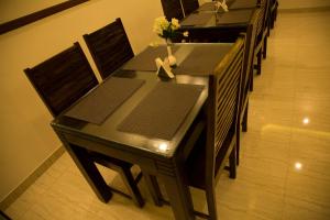 a dining room table and chairs with flowers on it at Hotel Grand Tree in Coimbatore