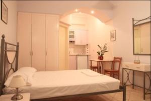 a bedroom with a bed and a table and a kitchen at Aigiali Rooms in Volissos