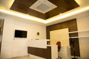 a living room with a coffered ceiling and a tv at Hotel Grand Tree in Coimbatore