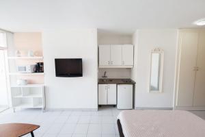 Una habitación blanca con una cama y una cocina. en Apartamento Tobago, en Puerto Rico de Gran Canaria