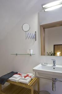 La salle de bains est pourvue d'un lavabo, d'un miroir et de serviettes. dans l'établissement Vico Amato Residenza, à Sulmona