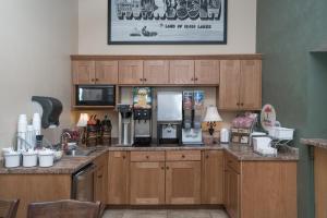 a kitchen with wooden cabinets and a counter top at Super 8 by Wyndham Willmar in Willmar
