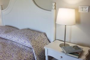 una lámpara en una mesita de noche junto a una cama en Casa Valliprata en Bucciano