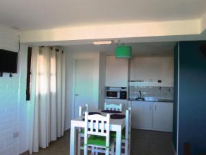 uma cozinha e sala de jantar com mesa e cadeiras em Cabañas La Casa de Adriana em Merlo
