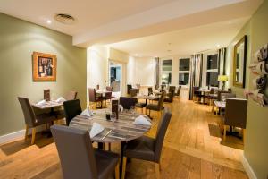 a dining room with a table and chairs at Stanwell Hotel By Mercure in Stanwell