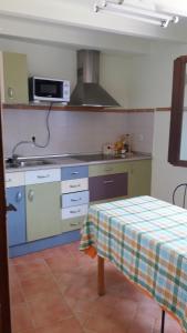 a kitchen with a table and a stove top oven at La Casa Azul in Yosa de Sobremonte