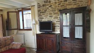 a living room with a tv on a wooden cabinet at La Casa Azul in Yosa de Sobremonte