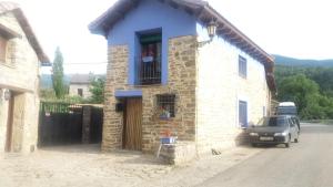 a stone house with a window and a car parked outside at La Casa Azul in Yosa de Sobremonte