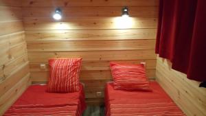 two beds in a sauna with wooden walls and lights at La Grange et Le Nid in Biscarrosse