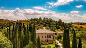 dom w środku lasu drzew w obiekcie Villa Armena Relais w mieście Buonconvento