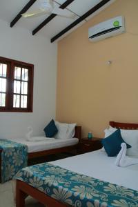een slaapkamer met 2 bedden en een ventilator bij Soma villa in Galle