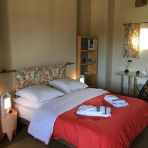 a bedroom with a red bed with towels on it at Coeur De Beaujolais in Corcelles-en-Beaujolais
