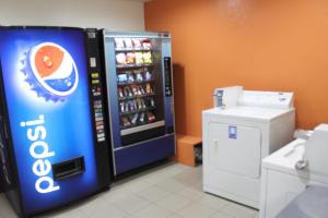 a soda machine in a room with a drink cooler at Ashley Inn Ponca City in Ponca City