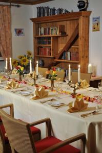 Una larga mesa blanca con velas y flores. en Hotel Hohenstaufen en Göppingen