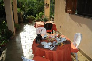 una mesa con un mantel rojo en el patio en B&B Villa Calagioli, en Castelbuono