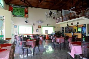 a dining room with pink tables and chairs at Pousada Victor in Ribeirão Claro