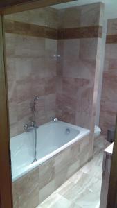 a bath tub with a faucet in a bathroom at Hotel de l'Orangerie in Strasbourg