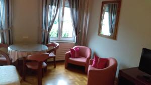 een kamer met stoelen, een tafel en ramen bij Hotel de l'Orangerie in Straatsburg