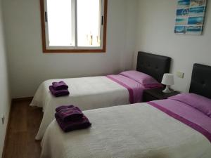 ラスパルマス・デ・グランカナリアにあるApartamento mirador del Marの紫の毛布が備わる客室のベッド2台