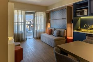 a living room with a couch and a table in a room at Mercure Sao Paulo Barra Funda in Sao Paulo