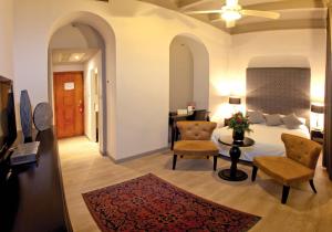 - une chambre avec un lit, deux chaises et une table dans l'établissement Notre Dame Center, à Jérusalem