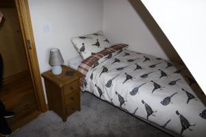 1 dormitorio con 1 cama y 1 mesa con lámpara en Thonock lane lodge, en Gainsborough