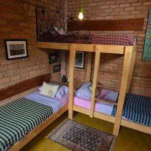 hostelvi guesthouse في لينكويس: سريرين بطابقين في غرفة مع جدار من الطوب
