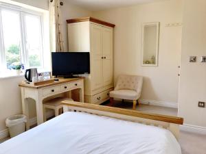 a bedroom with a bed and a desk with a television at Moon House in Oxford