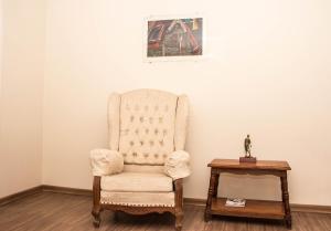 a chair sitting in a corner with a table at Dalle Hotel in Bagé