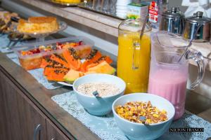 a kitchen counter with bowls of food and drinks at Dalle Hotel in Bagé