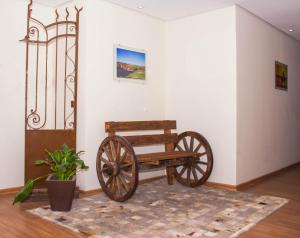 a wooden bench sitting in a room next to a wall at Dalle Hotel in Bagé