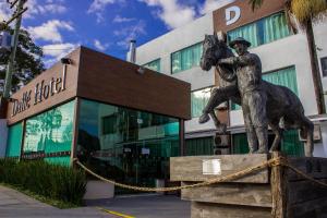 a statue of a man riding a horse in front of a building at Dalle Hotel in Bagé