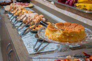 a buffet line with a cake on a table at Dalle Hotel in Bagé
