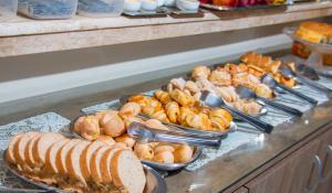 a buffet line with various types of bread and pastries at Dalle Hotel in Bagé