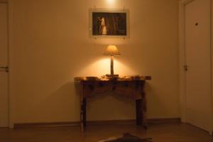 a table with a lamp on it in a room at Dalle Hotel in Bagé