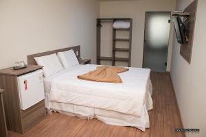 a bedroom with a bed with a hat on it at Dalle Hotel in Bagé