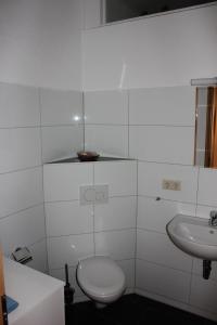 a white bathroom with a toilet and a sink at Ferienwohnung Bonita in Freital