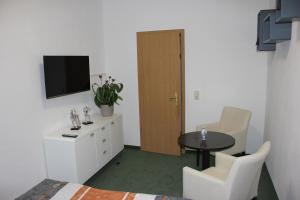 Cette chambre dispose d'une table, d'une télévision, d'une table et de chaises. dans l'établissement Ferienwohnung Bonita, à Freital