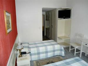 Habitación de hotel con cama y TV en Ancona Center Hotel en Amparo