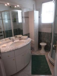 a bathroom with a sink and a shower and a toilet at Boléro in Carqueiranne