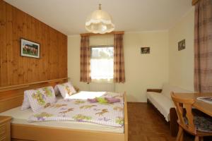 a small bedroom with a bed and a table at Familienparadies Zeislerhof in Glanegg